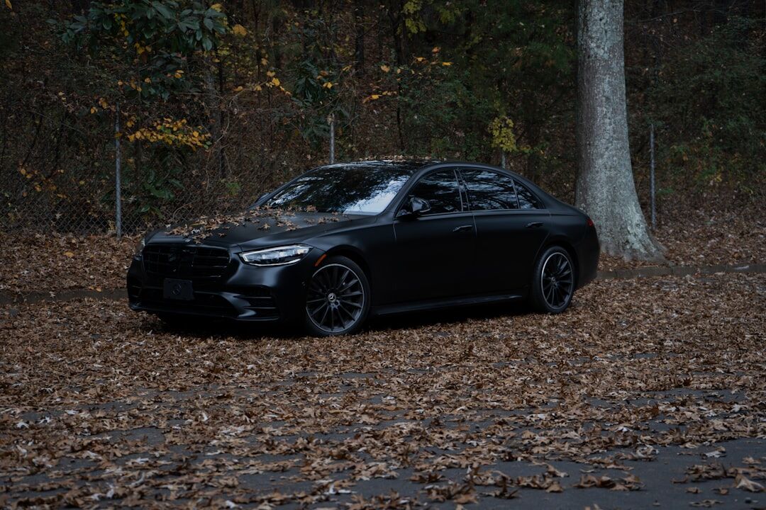 Black executive sedan parked in a modern showroom