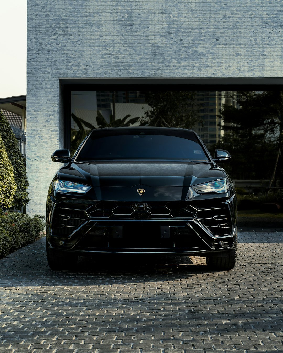Black luxury SUV parked in front of a modern mansion