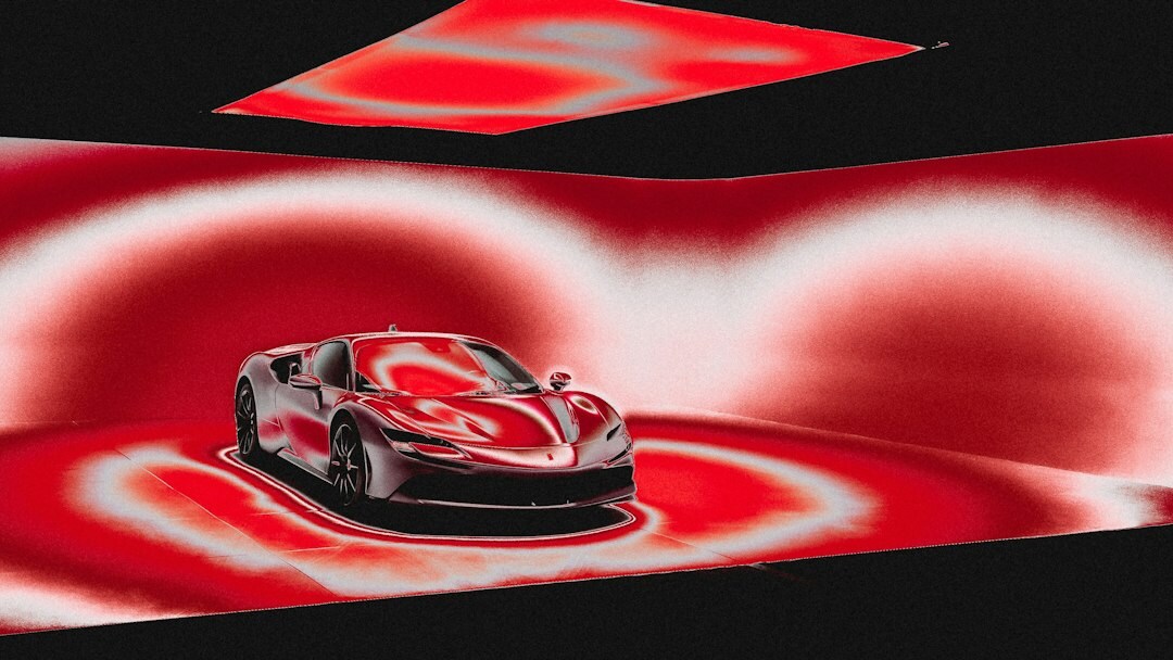 Red luxury sports coupe on display under studio lighting