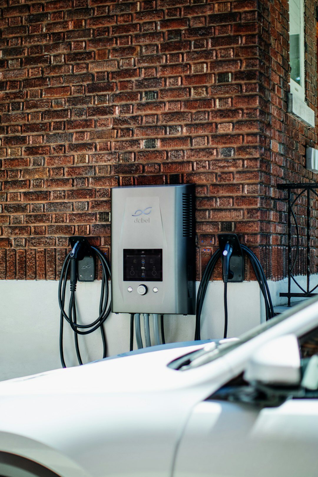 White electric SUV parked near a home charging station