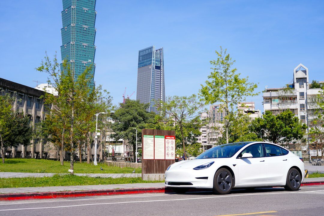 Modern electric car driving through a green city street