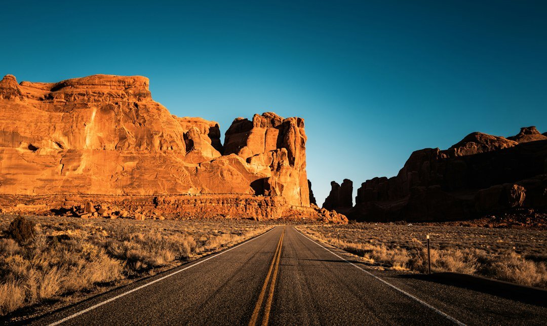 American highway with a pickup truck driving at sunset