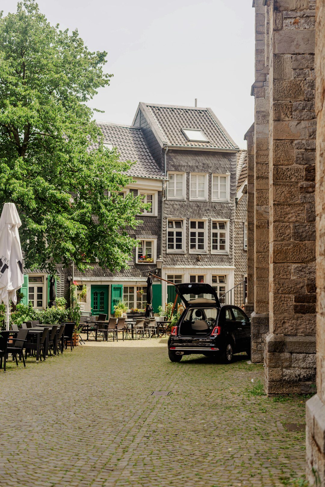 European hatchback parked on a cobblestone street